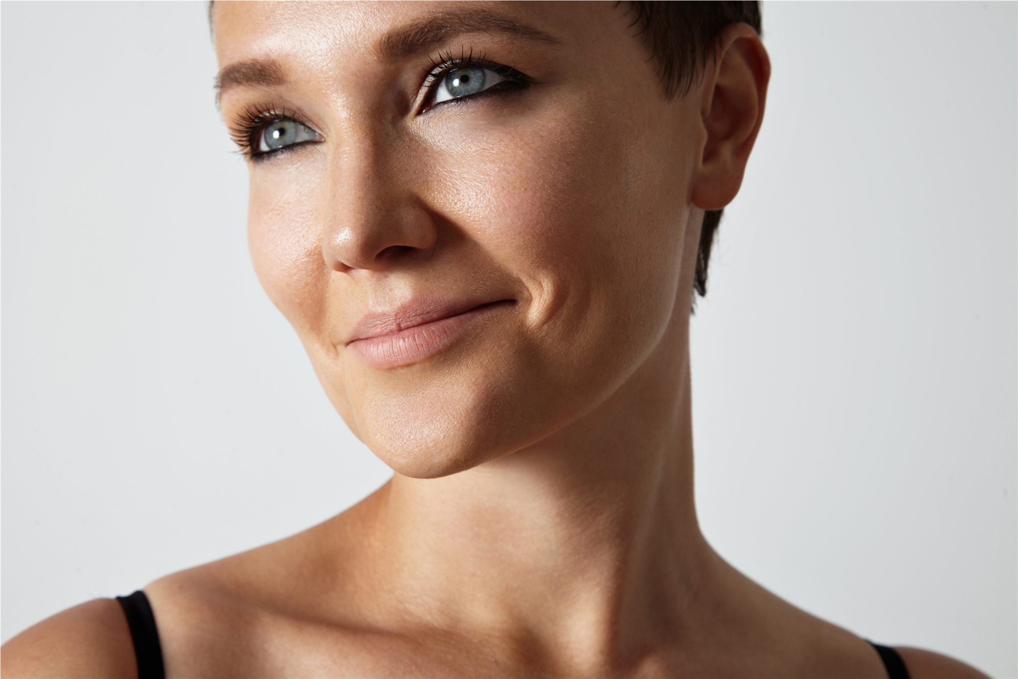 Mulher com expressão natural após rejuvenescimento facial